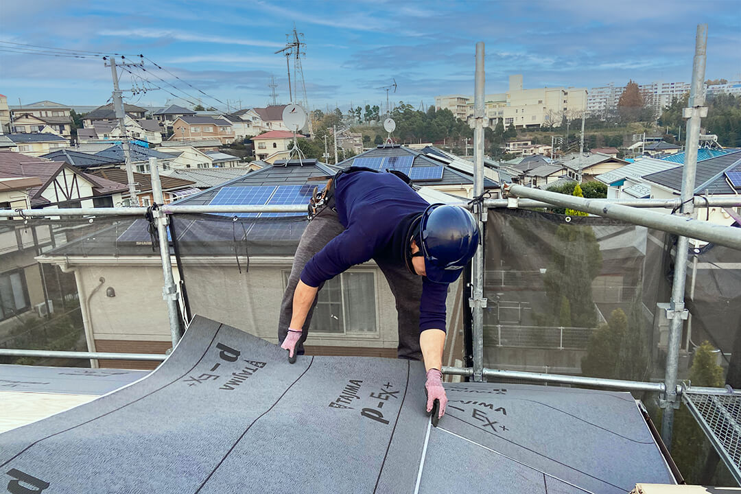 屋根修理をする男性